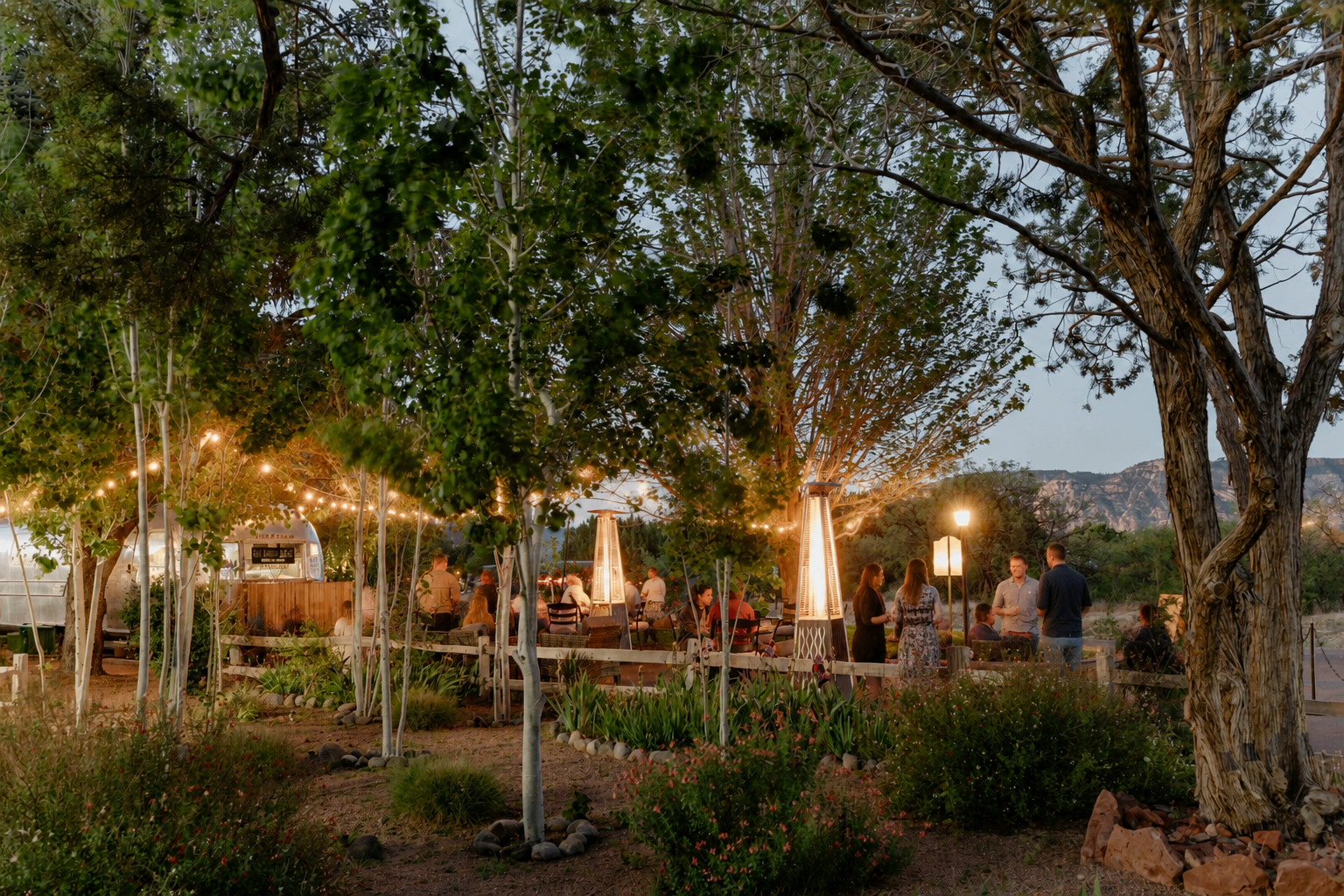 Outdoor reunion party setup at Sky Ranch Lodge among the trees and string lights