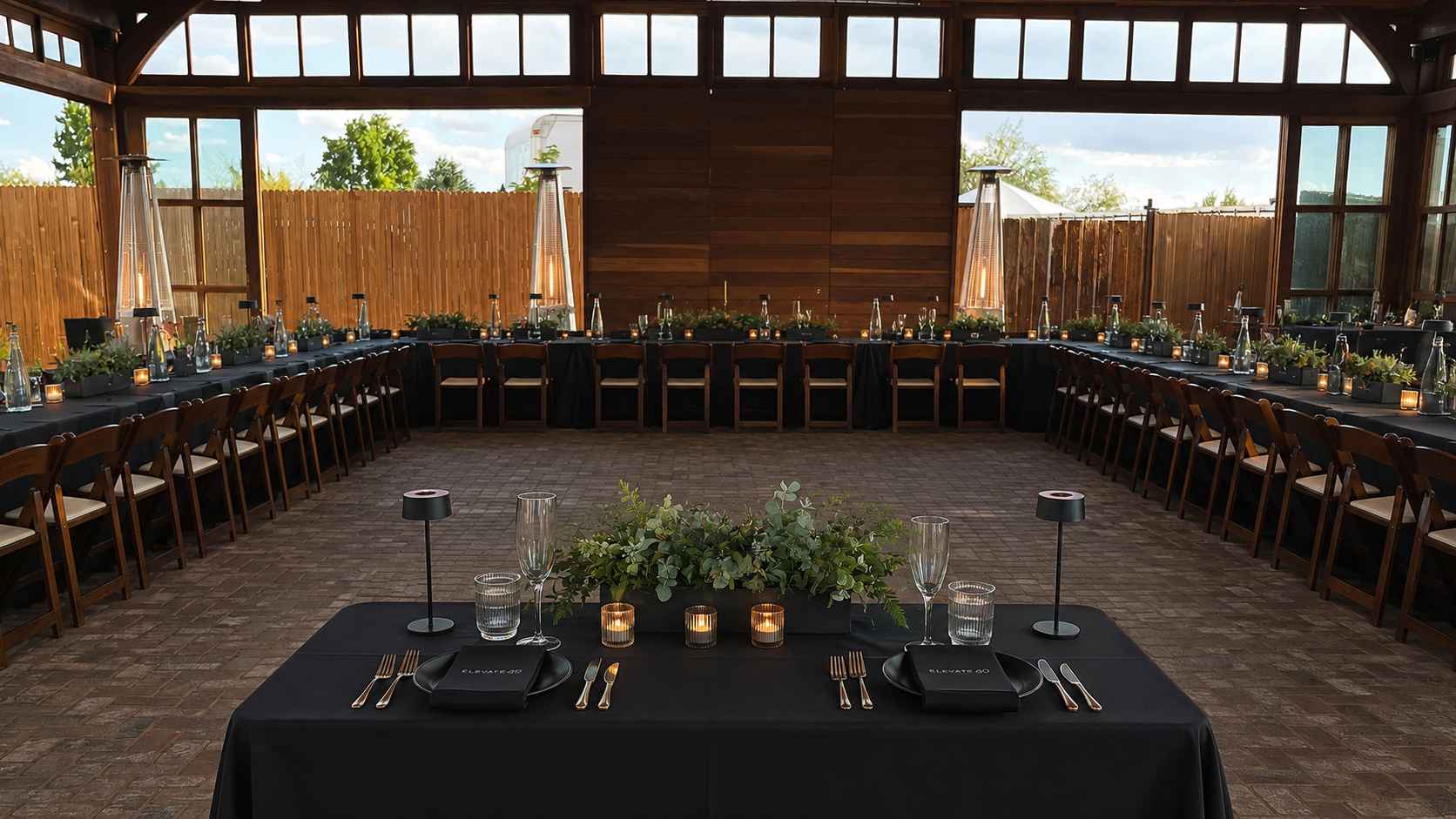 Corporate dinner setup with long banquet tables and candlelight inside The Pavilion