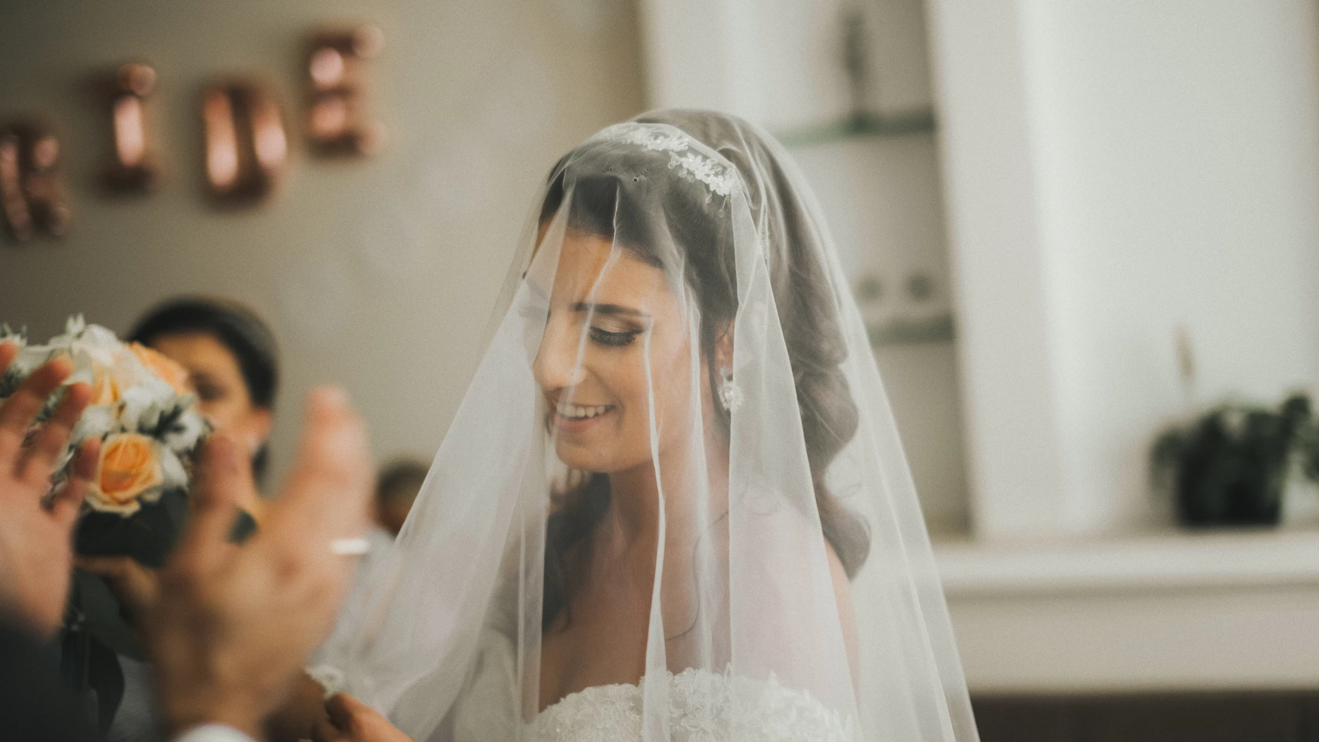 Bride's white dress hanging on a rustic wood post