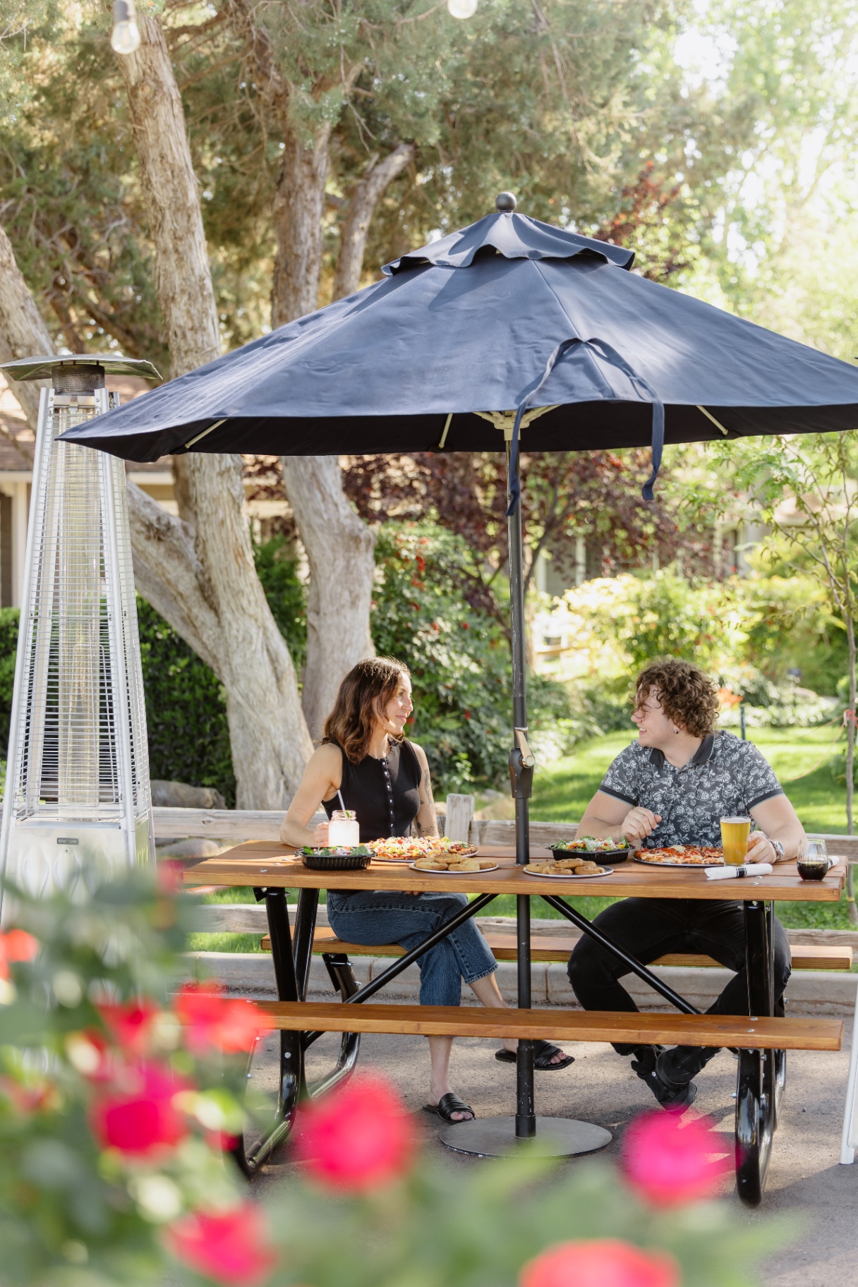 Guests dining under an umbrella in the garden
