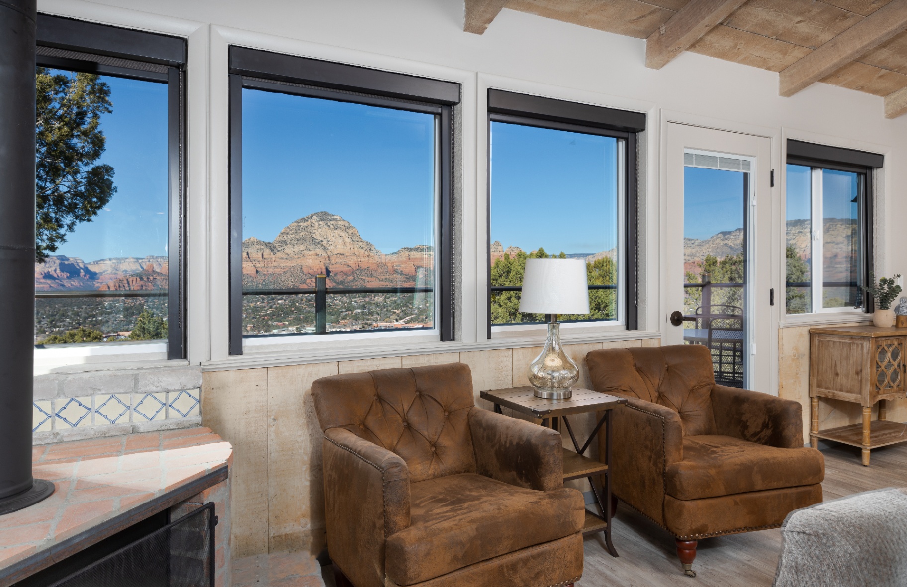 Lounge chairs framing wide windows onto the red rocks