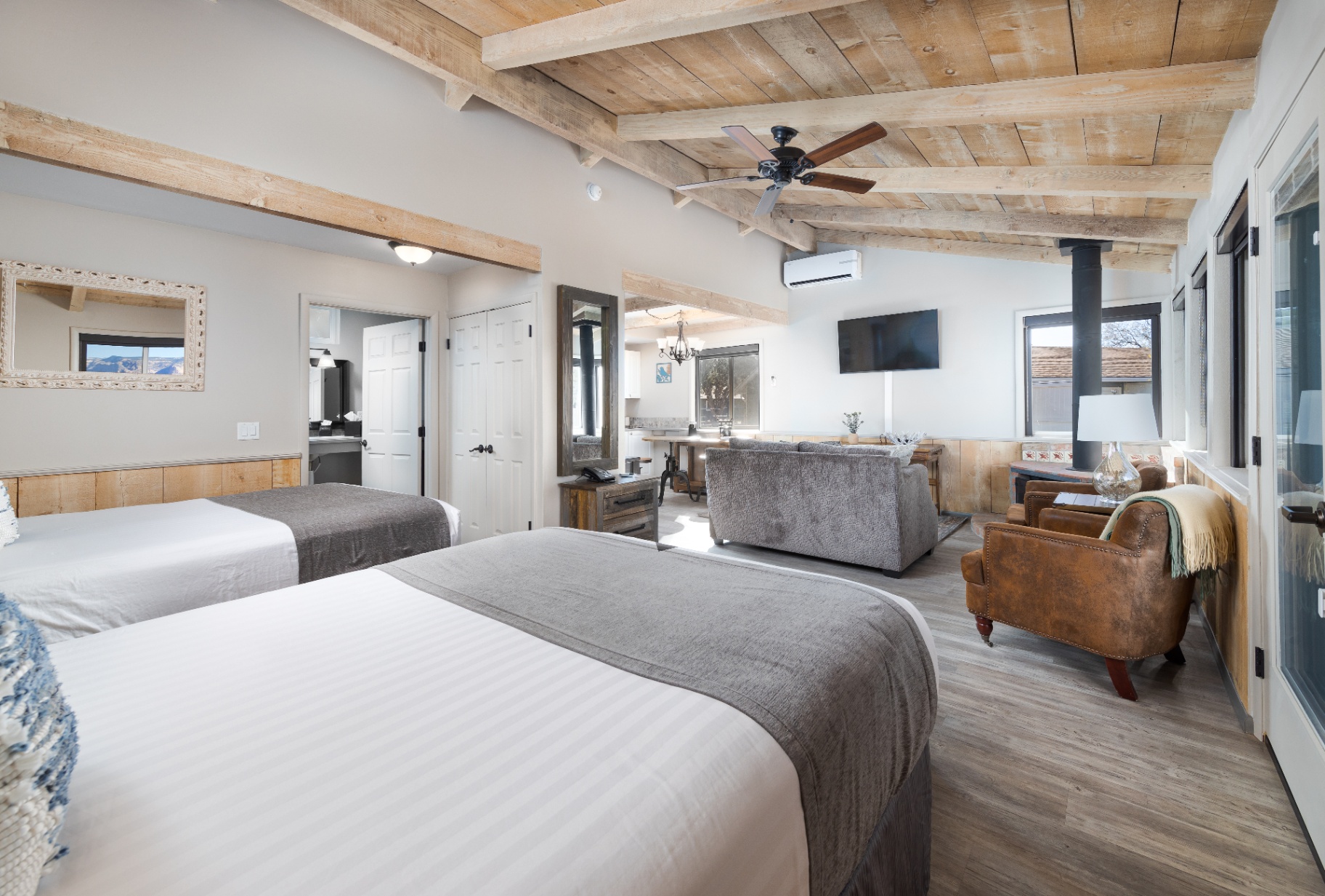 Wide queen cottage interior with two beds, lounge and fireplace