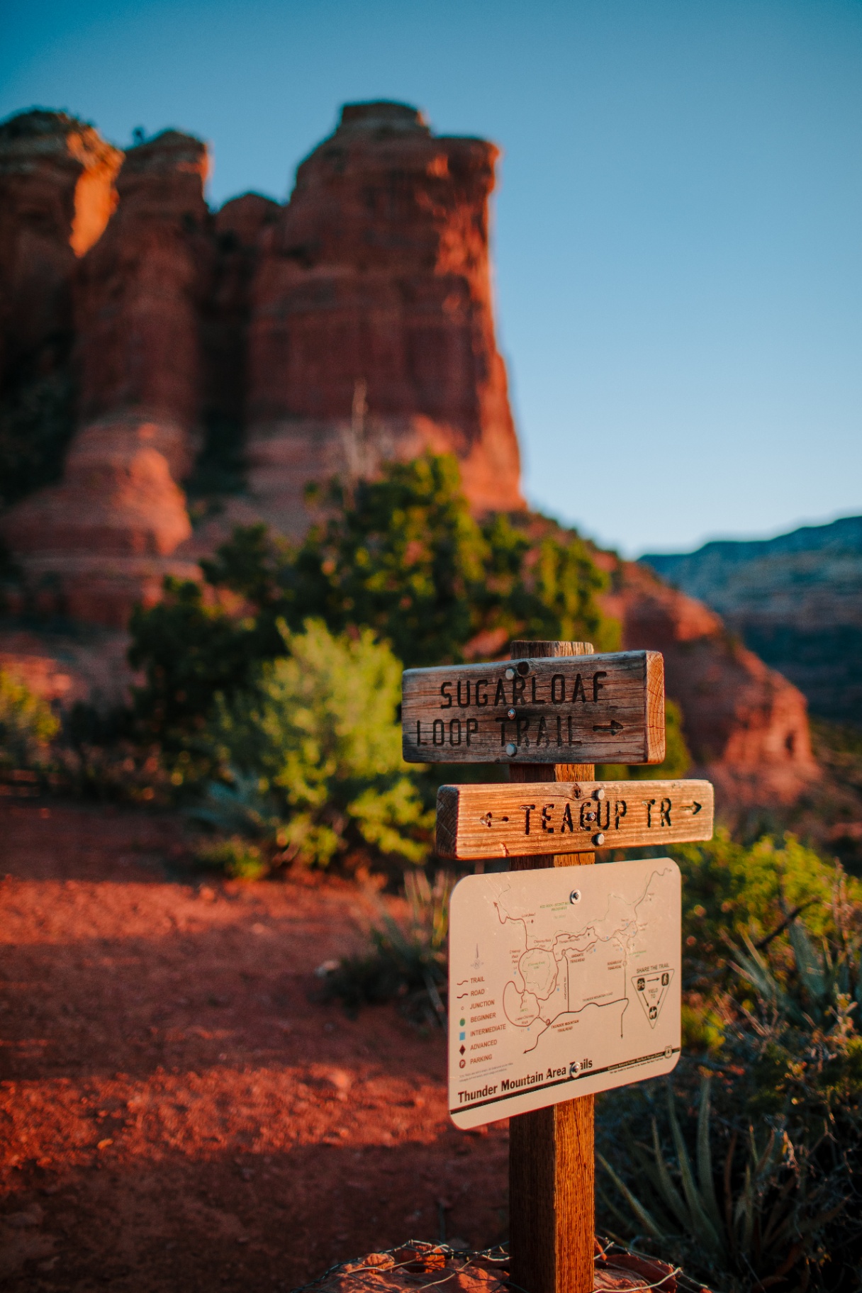 Sugarloaf Loop Trail sign in front of towering red rocks